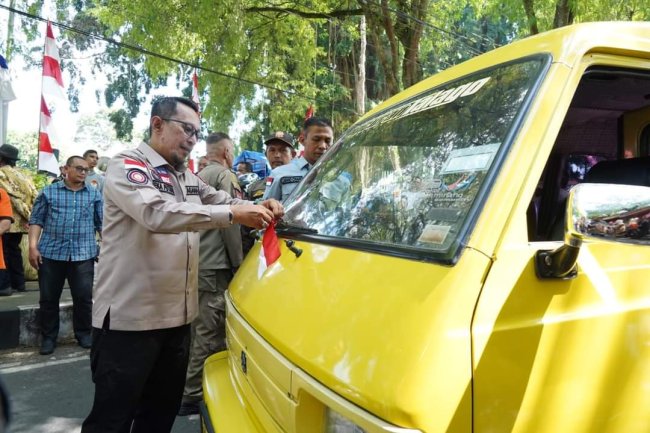 Sambut HUTRI. Bupati Eka Putra Bagikan Bendera Kepada Masyarakat 